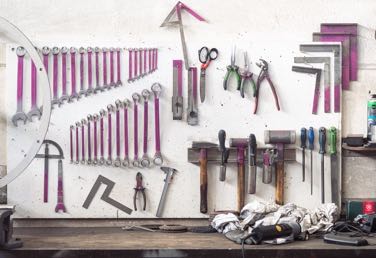 Werkzeuge für die Metallbeareitung hängen über einer Werkbank